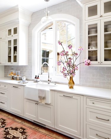 integrated kitchen appliances with farmhouse sink in white kitchen
