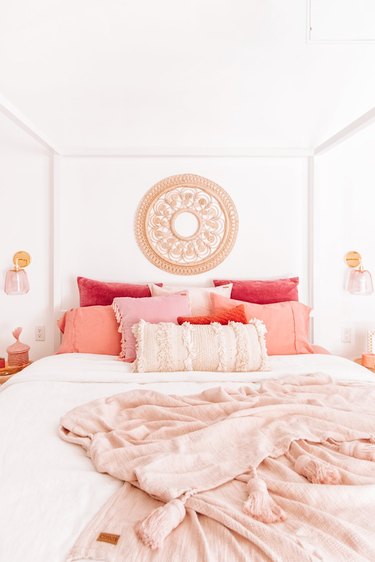 rattan wall hanging in pink and white bedroom