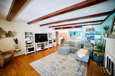 living room space with white ceiling and exposed wood beams