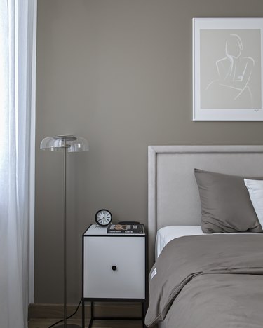 Glass-topped floor lamp in gray bedroom