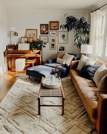 vintage living room style with piano and leather sofa and gallery wall