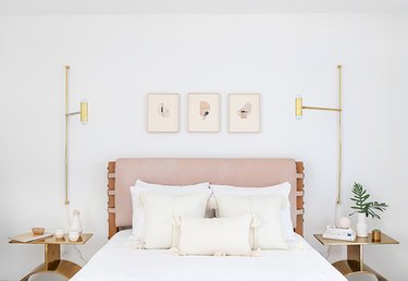 Идея гостевой спальни с розовым мягким изголовьем и латунными акцентами
