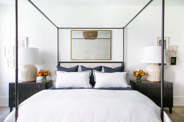 Bedroom mirror above canopy bed with dark wood nightstands
