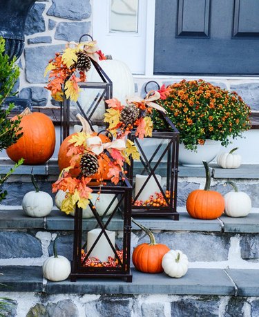 fall-inspired candle lanterns lighting front porch