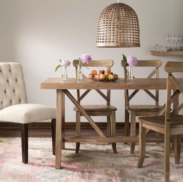 Target farmhouse furniture with rustic wooden dining table and chairs with woven pendant hanging above