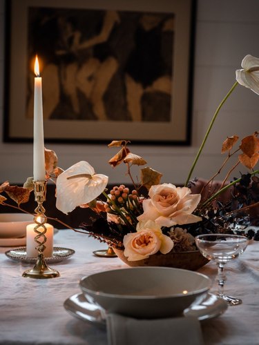 fall floral arrangement with candles on white table