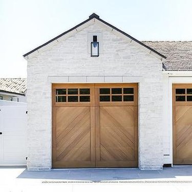 chevron patterned wooden garage doors on white home exterior