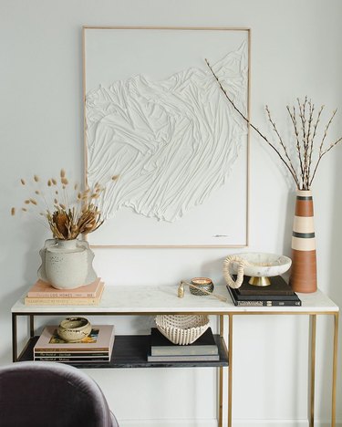 two fall floral arrangements on console table