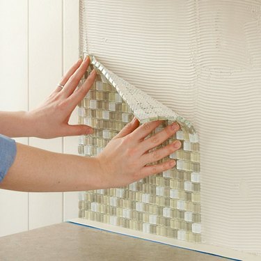 pressing wall tile into mastic