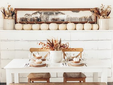 fall floral arrangement on table with mini white pumpkins