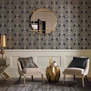 living room space with art deco wallpaper, two chairs and mirror
