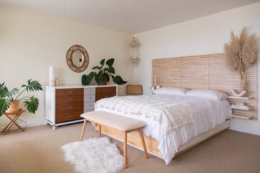 bedroom space with wood headboard and white bedding