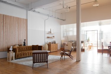 office space with white walls, mustard couch and wood chairs