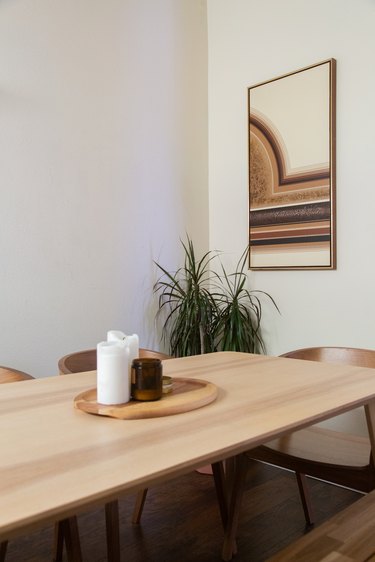 wood table and chairs with artwork on the wall