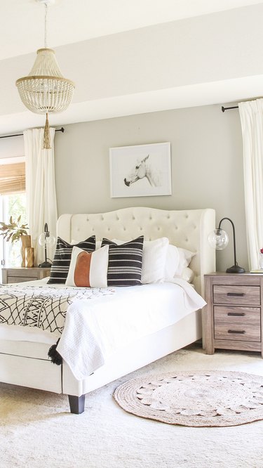 contemporary neutral bedroom color idea with chandelier and tufted headboard
