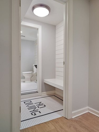 bathroom with black and white mosaic floor tile and shiplap walls