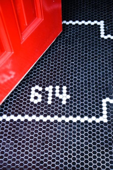 entryway with red door and black and white hex tile
