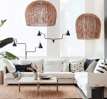 bohemian living room lighting idea with rattan pendants and articulating wall sconces