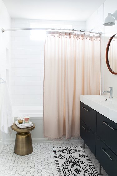 A bathroom with a pink shower curtain