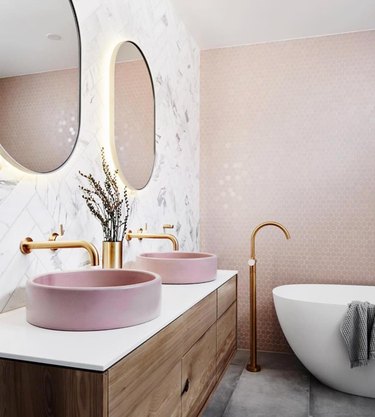 A bathroom with a pink tile wall
