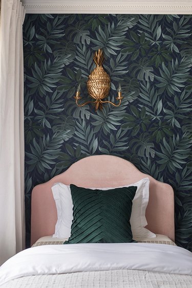 bohemian bedroom lighting idea with pineapple shaped wall sconce above pink upholstered headboard