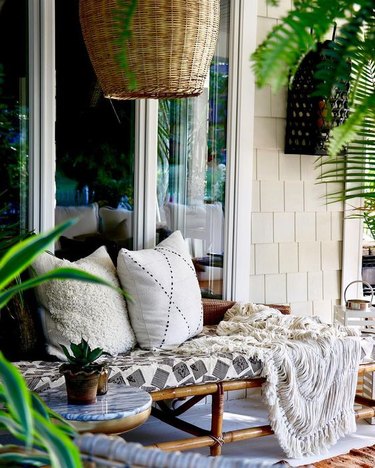 rattan daybed with accent pillows and throw blanket