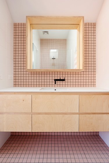 bathroom with pink mosaic tile and floating vanity