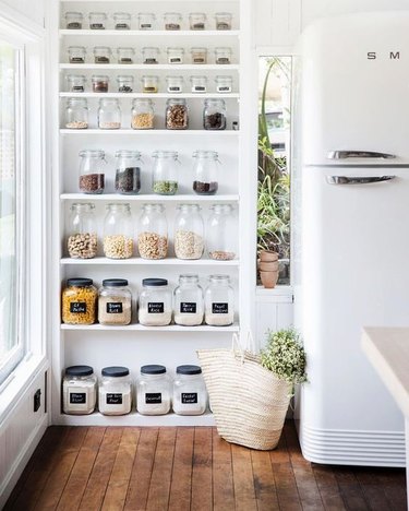organized small pantry closet with glass jars and containers