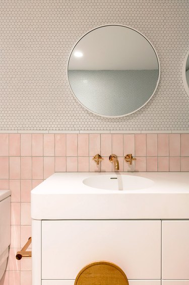 bathroom with pink tile wainscot and round penny tile