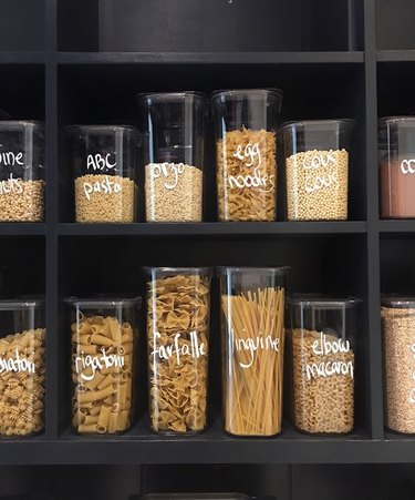 organized small pantry closet with labeled containers