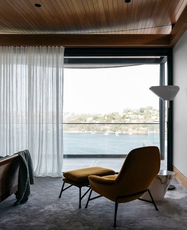 Contemporary apartment with mustard chair and current floor lamp