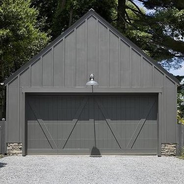 weathered gray wooden garage doors with wall sconce above