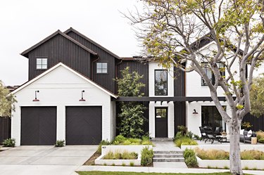 white and black exterior with black garage doors