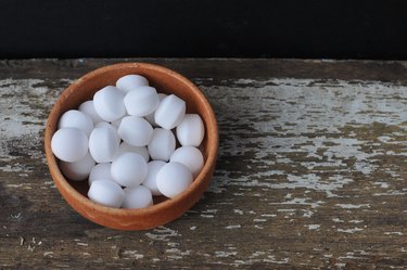 High Angle View Of Mothballs In Bowl On Wooden Table