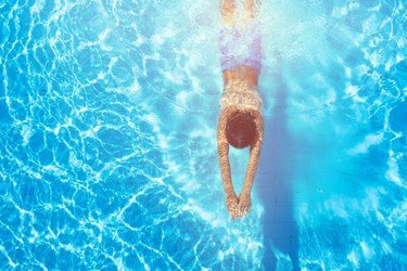 Happy boy diving in the swimming pool