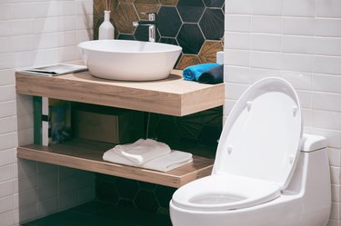 Modern bathroom with bright tiles and white toilet and sink.