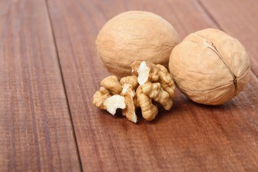 Ripe walnuts close-up on a brown wooden table