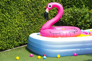 Inflatable pool with flamingo balloon in garden