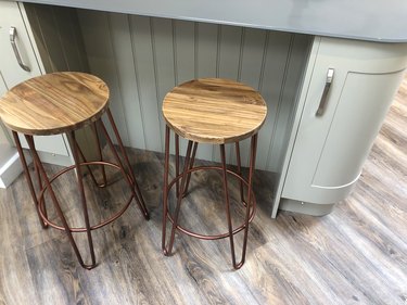 Image of curved kitchen floor cabinets painted duck egg blue, breakfast bar / kitchen island tongue and groove cladding timber, grey composite corian worktop countertop, oak wood stools with copper coloured metal legs on dark oak effect laminate floors