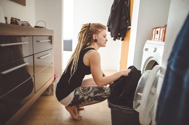 Young woman doing laundry at home.