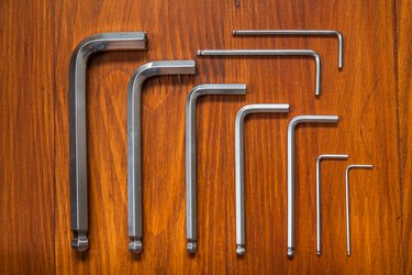 Set of hexagonal keys on a wooden background. Knolling style shot.