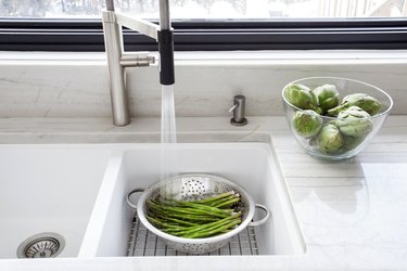 Washing fresh asparagus in the Kitchen sink.