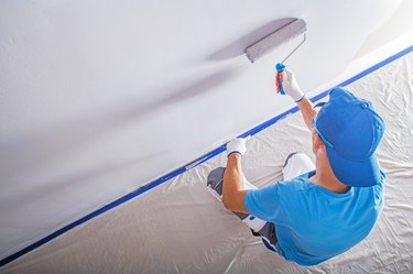 High Angle View Of Worker Painting On Wall At Home