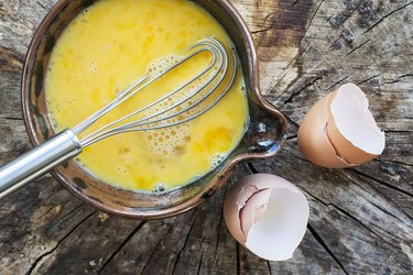 Beaten eggs and whisk in a ceramic bowl
