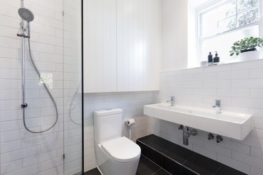 Small ensuite bathroom with tiling laid in a brick pattern
