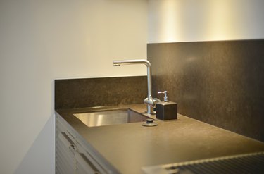 Luxury faucet on black sink with lighting in kitchen