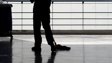 Silhouette image of cleaning service people sweeping floor with mop