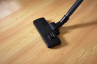 Old vacuum cleaner on parquet floor with copy space