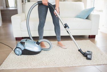 Woman hoovering rug