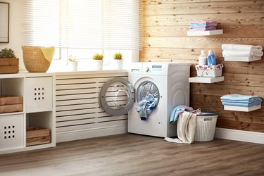 Interior of real laundry room with  washing machine at window at home